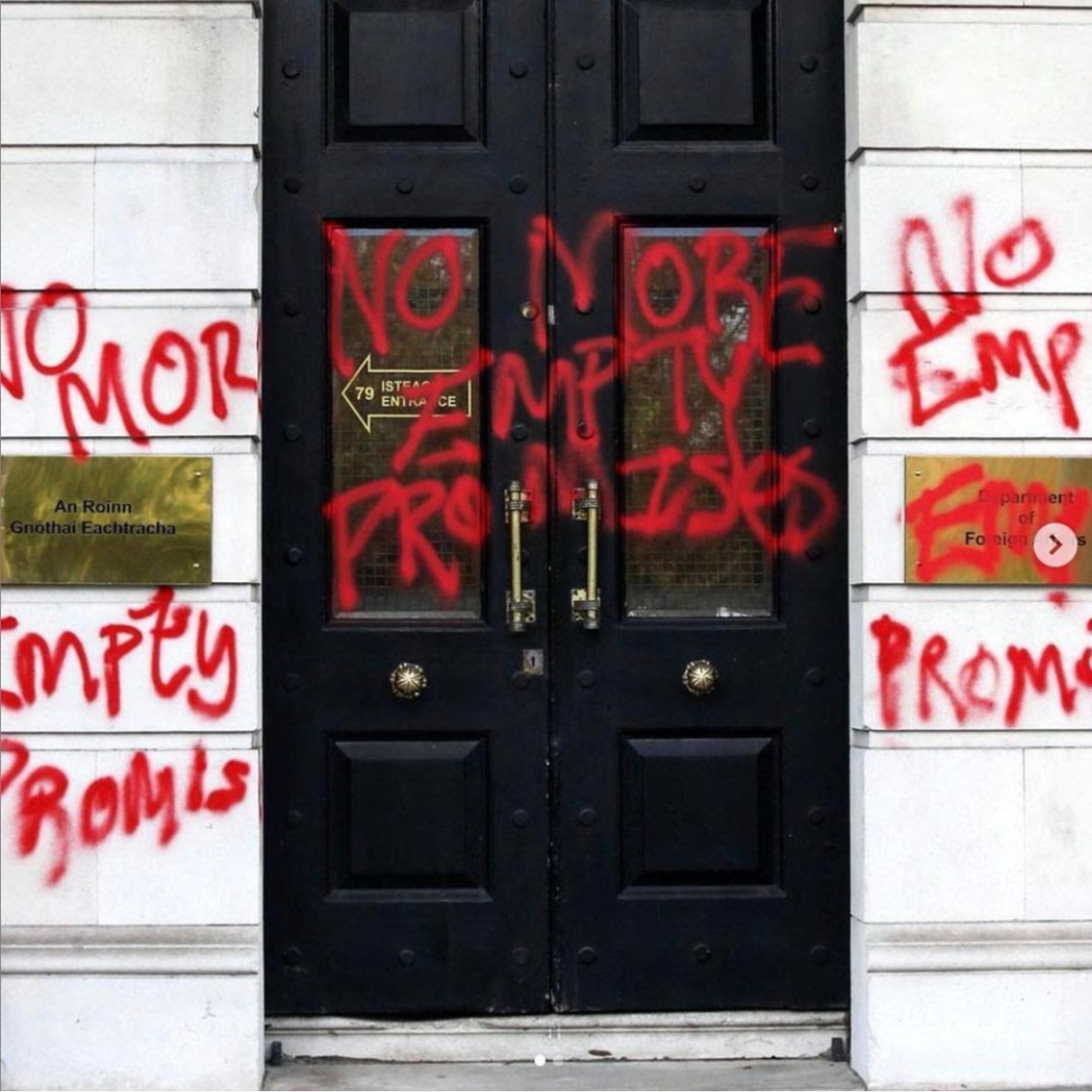 The door of the Department of Foreign Affairs in Dublin, Ireland, sprayed with red paint that spells out 'No More Empty Promises' three times.