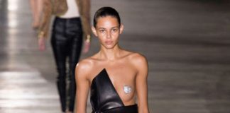 model walking down the runway wearing a dress that exposes one nipple