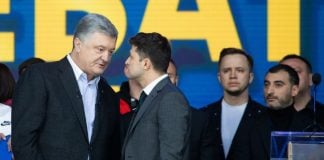 The image shows Petro Poroshenko and Vladimir Zelensky engaging in a debate on the 19th of April 2019. They are in front of a blue background.