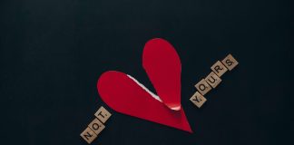 A ripped red paper heart on a dark blue background with the scrabble letters 'Not yours'.