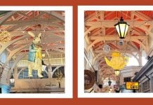 Two framed images of a rabbit and a teapot from Alice in Wonderland hanging in covered market.