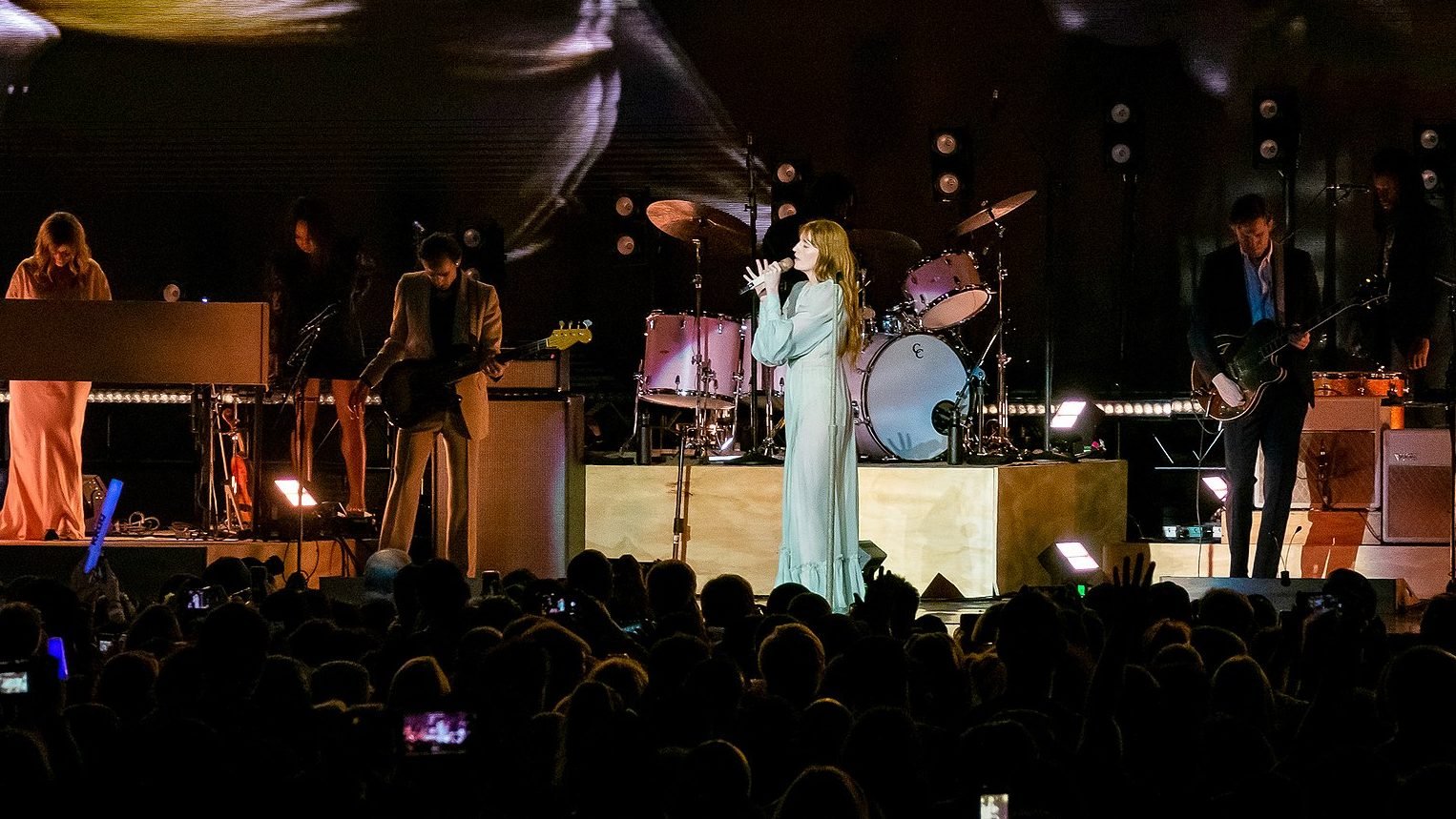 Florence Welch and six band members on stage.