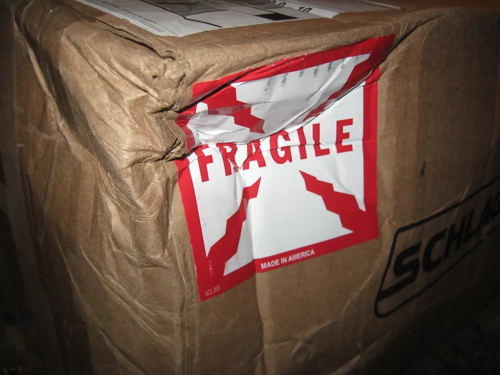 alt= A damaged box with a fragile sticker on it.