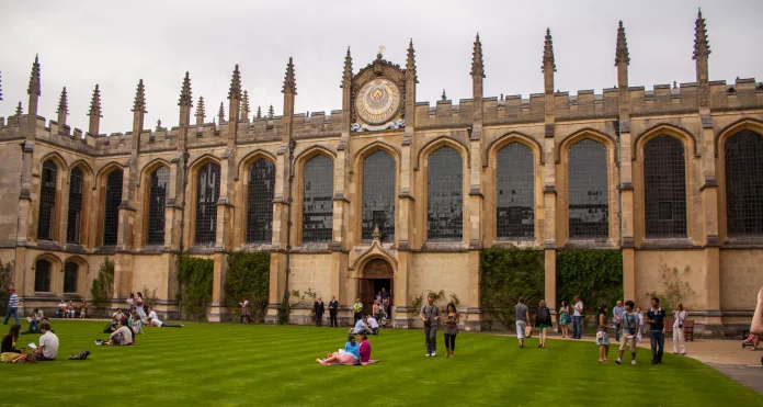 All Souls Codrington Library viewed from inside the quad, people lying on the grass