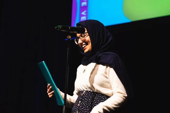 Image of Begum reading poetry on stage