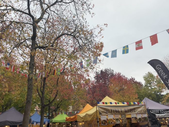 image of stalls in Gloucester Green food market during the fall with banner of flags above
