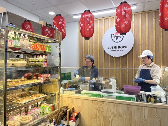 Storefront of Sushi bowl, with counter and refrigerated section