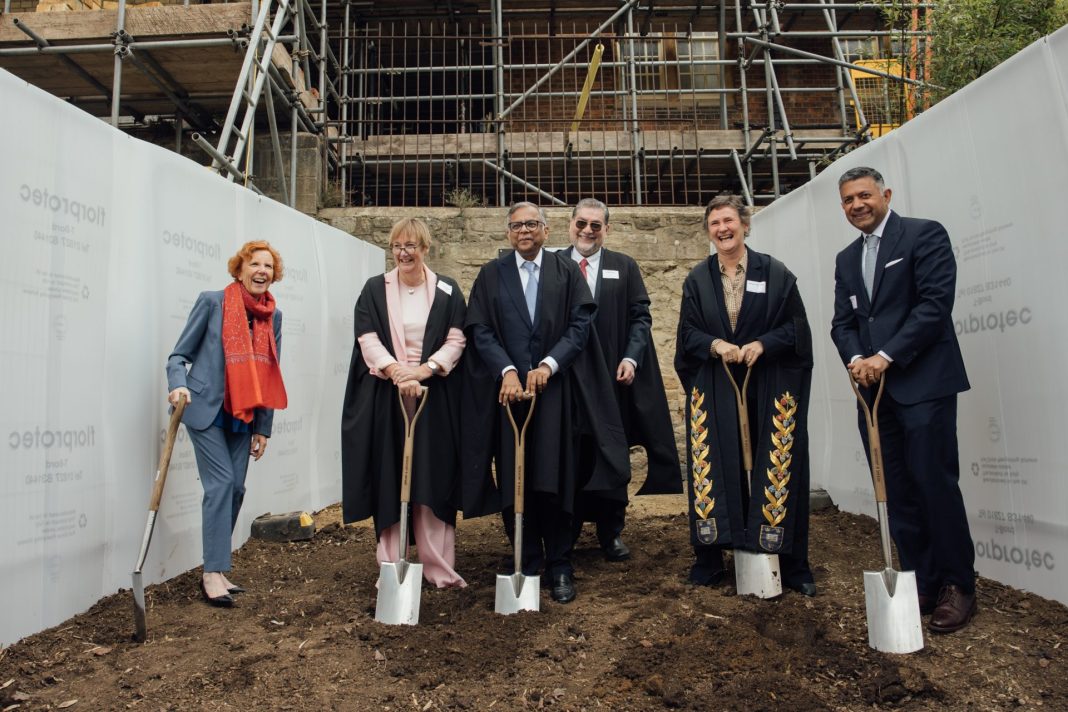 Irene Tracey and others hold shovels at the site of the future Ratan Tata building